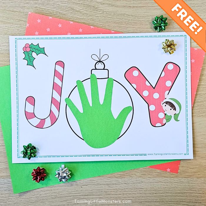 Completed Joy handprint craft for kids, gift toppers and Christmas themed craft paper.